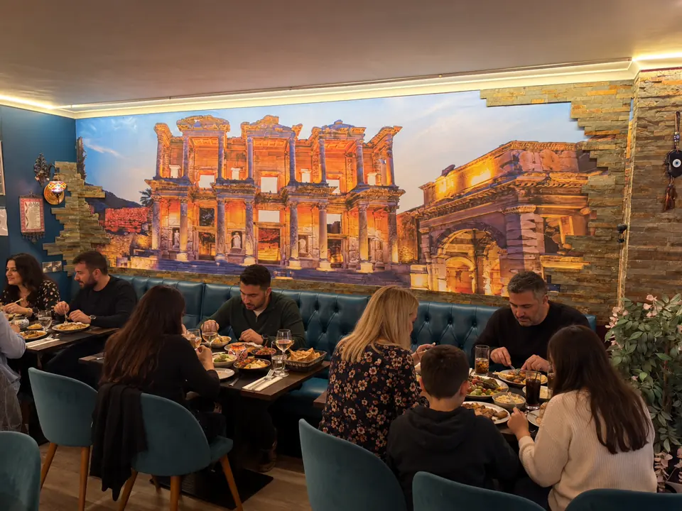 Families and friends dining in front of the Ephesus mural