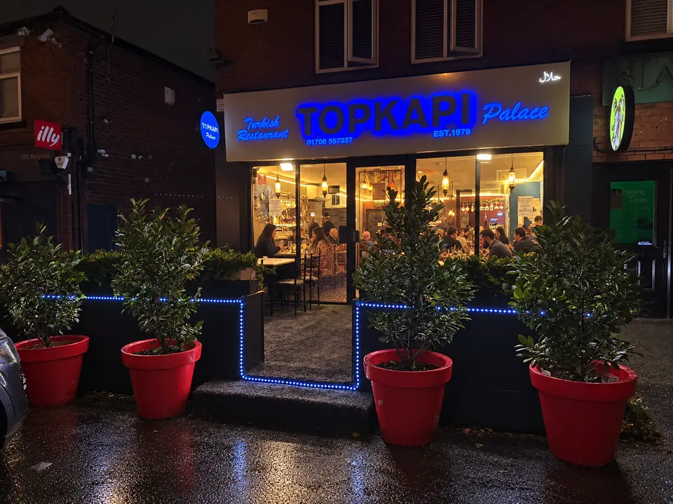 The Topkapi Palace shopfront on Bury Road at night, with diners inside